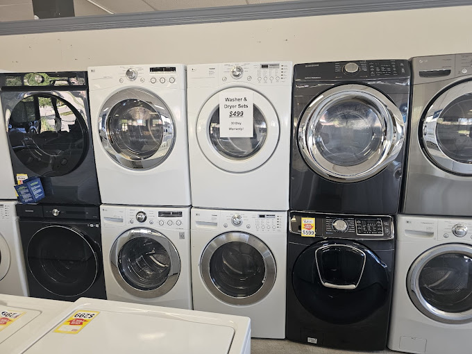 A bunch of washers and dryers in a store