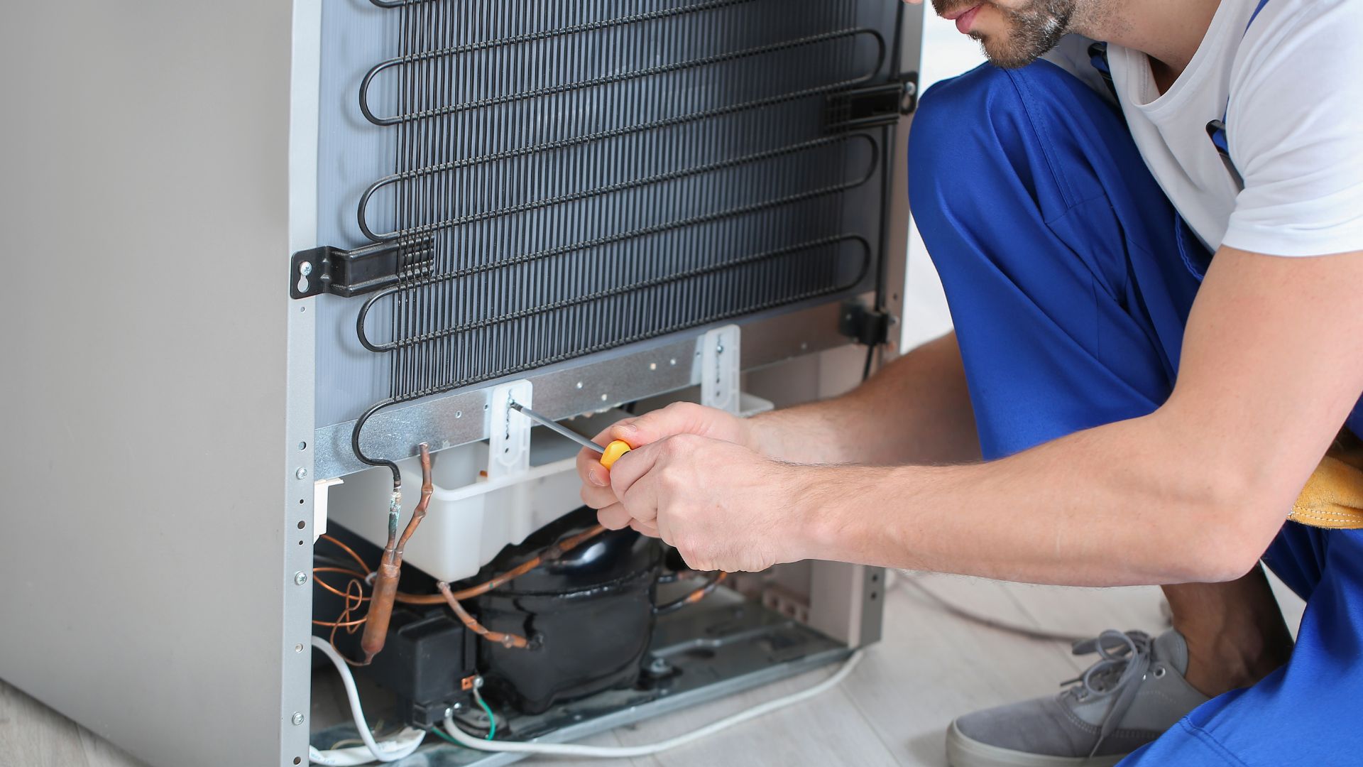 A man fixing an air conditioner in a room